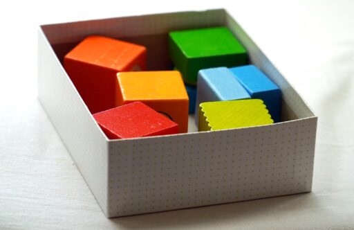 Kleurrijke magnetische bouwstaven en stalen bolletjes op een houten vloer, gerangschikt tot een kleine koepelconstructie