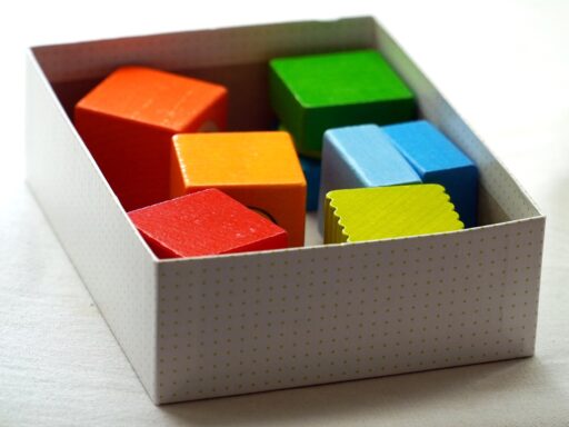 Kleurrijke magnetische bouwstaven en stalen bolletjes op een houten vloer, gerangschikt tot een kleine koepelconstructie