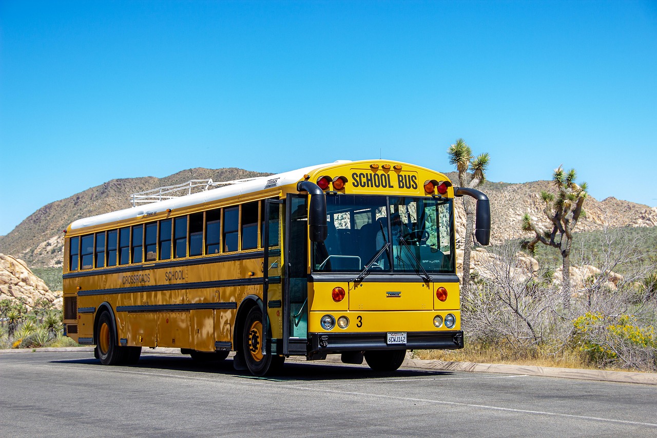 Kinderen staan vrolijk voor een bus klaar voor een schoolreisje