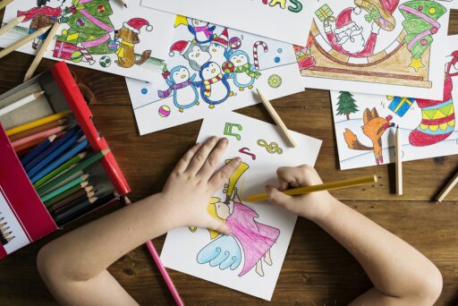 Kind tekent met potloden en viltstiften op papier voor een televisie