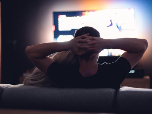 Een gezin op de bank kijkend naar de televisie op een gezellige avond thuis