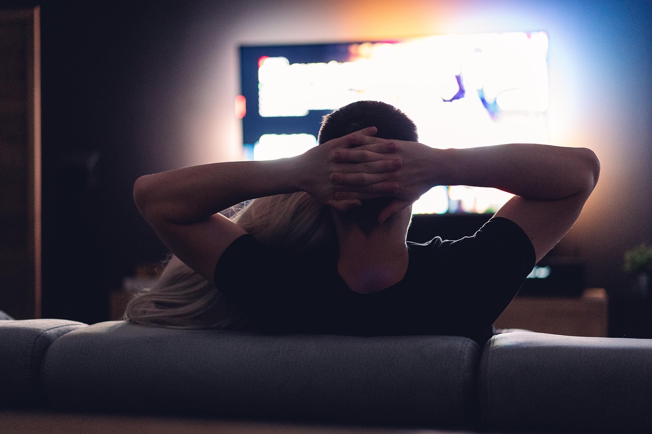 Een gezin op de bank kijkend naar de televisie op een gezellige avond thuis