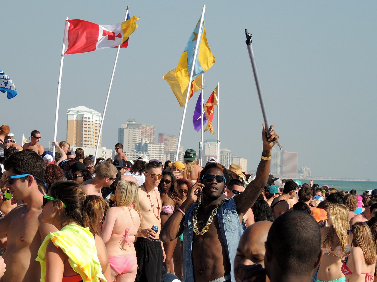 Groep mensen die plezier hebben op een zomers strand, typerend voor de jaren 90 stijl