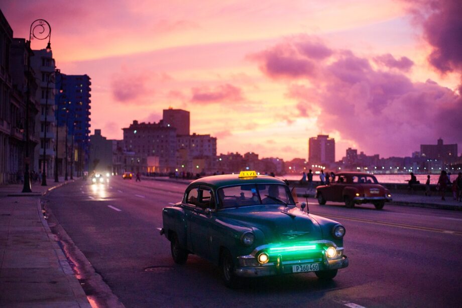 Een vintage auto rijdt 's nachts over een verlaten Amerikaanse snelweg, passend bij de sfeer van Radar Love