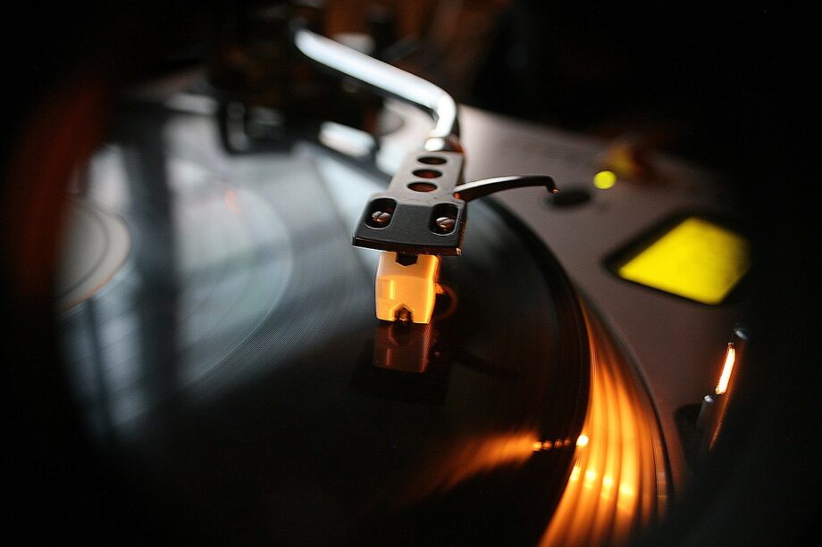 Een oude platenspeler op een zomers feestje in de jaren 80, omringd door vinyl platen