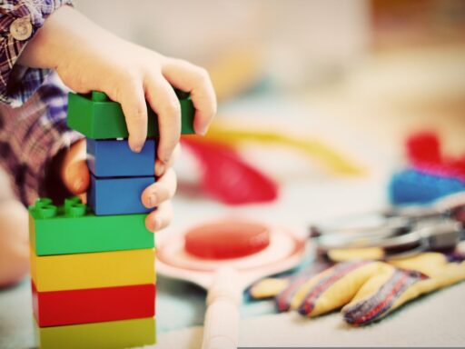 Roze houten blokken gestapeld tot een piramide, het klassieke Montessori-materiaal