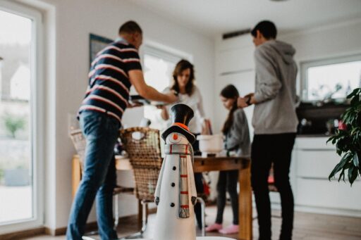 Man houdt toespraak aan een feestelijk gedekte familietafel met gasten die aandachtig luisteren