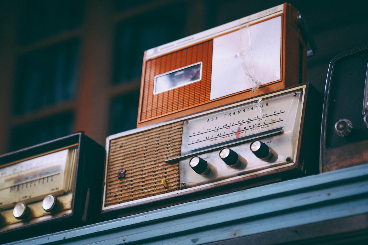 Een rode transistorradio op een houten campingtafel in de zomer