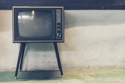 Een oude televisie in een woonkamer met zomers licht dat door de gordijnen valt