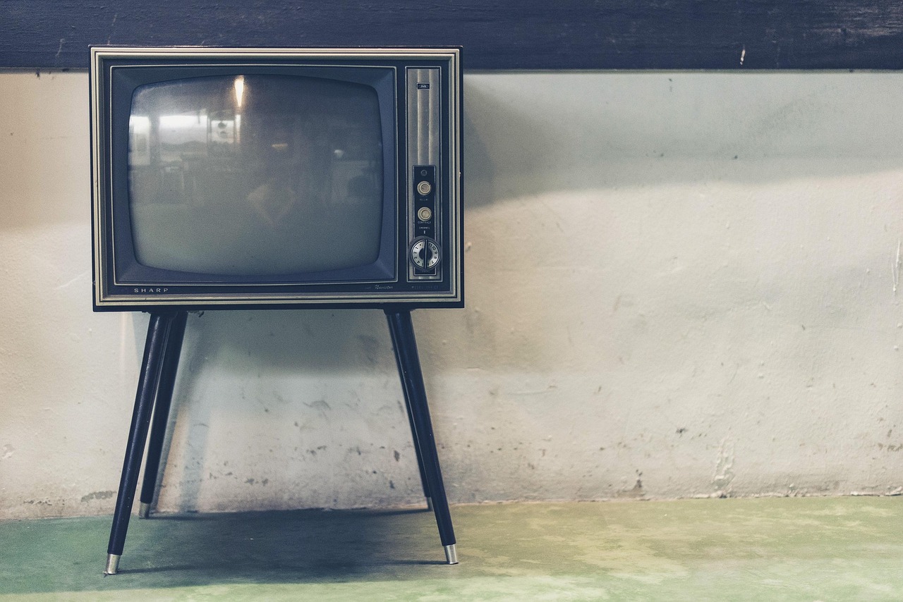 Een oude televisie in een woonkamer met zomers licht dat door de gordijnen valt