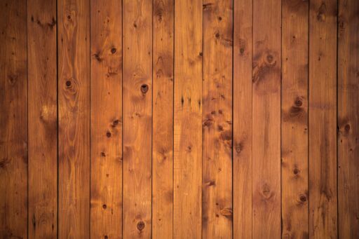 Een groot donkerbruin houten wandmeubel met glazen deurtjes en open planken, typerend voor de Nederlandse woonkamer in de jaren 80