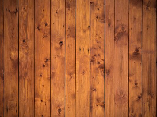 Een groot donkerbruin houten wandmeubel met glazen deurtjes en open planken, typerend voor de Nederlandse woonkamer in de jaren 80