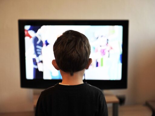 Kind in pyjama kijkt vroeg in de ochtend naar de televisie