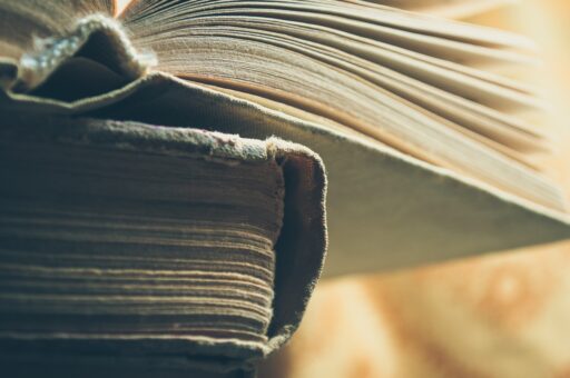 Rij versleten jeugdboeken op een houten bibliotheekplank