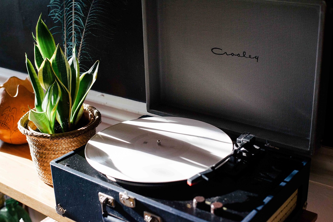 Een zilveren discman uit de jaren negentig op een houten tafel, met een cd half uit de speler