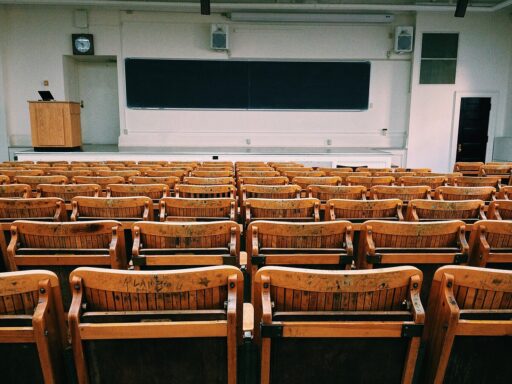 Een oud klaslokaal met houten banken en een schoolbord, symbool voor de basisschooltijd