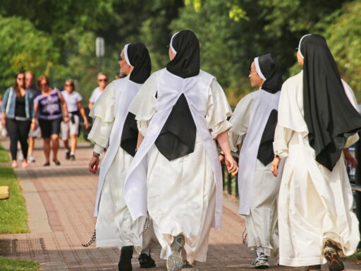 Een kind in een wit jeugdbewegingsuniform met das en muts, zoals bij de Patro vroeger